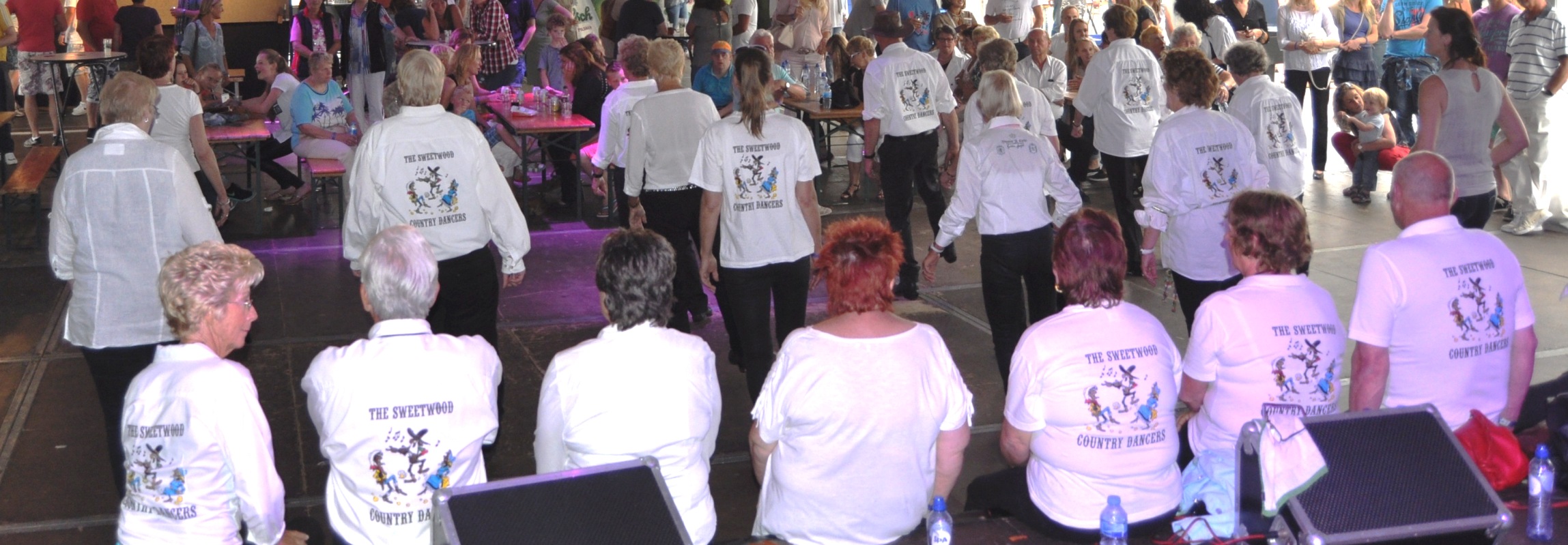 Sweetwood-dansers in witte clubshirts tijdens een historische avond